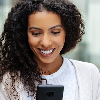 Woman smiling while using her cellphone