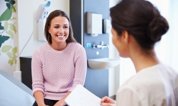 Woman in dental office smiling at dentist