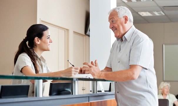 Man discussing flexible payment options with dental team member