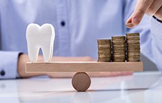 tooth balanced on a seesaw with a pile of coins