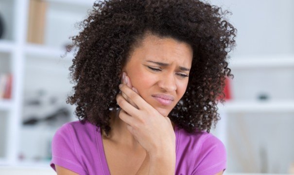 Woman in need of emergency dentistry holding jaw in pain