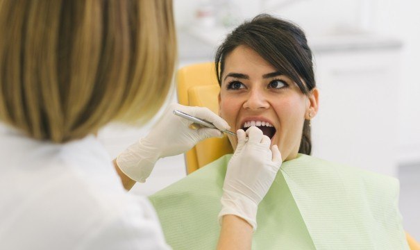 Woman receiving dental checkup to prevent dental emergencies