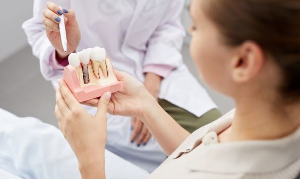 Dentist and patient discussing the four step dental implant process