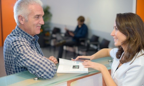 Dental team member and patient discussing the cost of dental implants