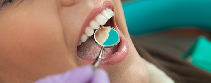 Dentist examining patient's smile after restorative dentistry