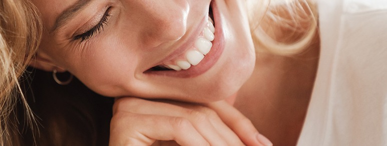 Woman smiling and resting her chin in her hand