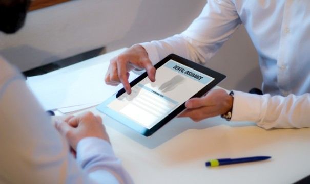 Dentist and patient looking at dental insurance forms on tablet computer