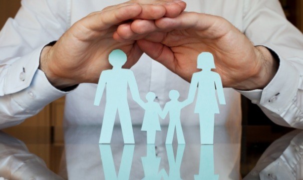 Hands covering paper cut out family