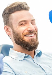 patient smiling while looking in dental mirror 