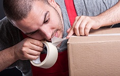 A man biting off tape with his teeth