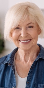 Woman with flawless smile after replacing missing teeth