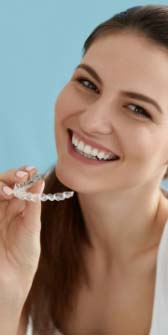 Smiling woman placing clear aligner tray