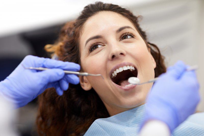 patient smiling while lying in dental chair