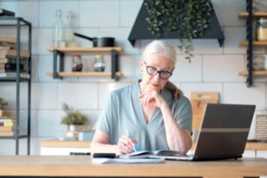 mature woman writing on notepad