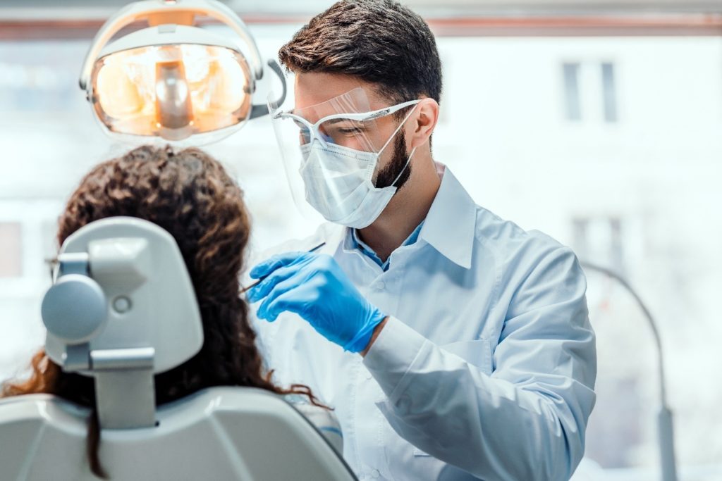 dentist cleaning patient's teeth and gums