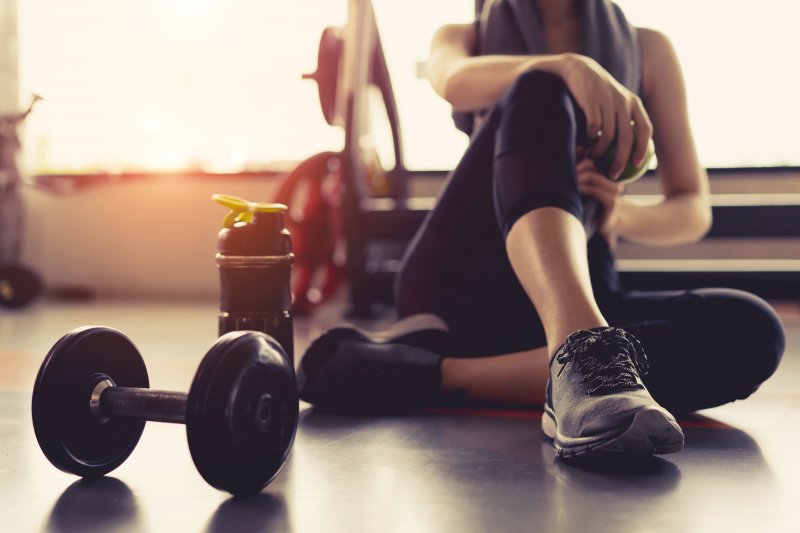 A woman relieving stress by lifting weights to help with her new dental implants