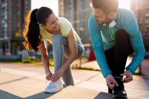 A man and a woman tying their shoes about to go for a run