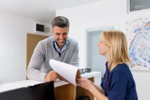 a patient speaking with a dental insurance coordinator at a dental office